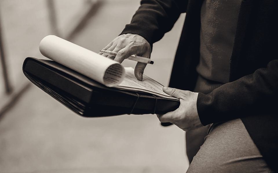 Hands holding a clipboard of documents