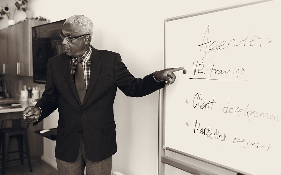 Manager mapping out his team's work on a whiteboard